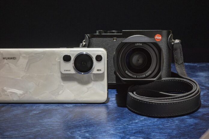 Huawei P60 Pro y la cámara Leica Q3 uno al lado de otro sobre una mesa azul