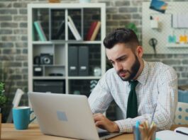 man sitting and working on laptop at office