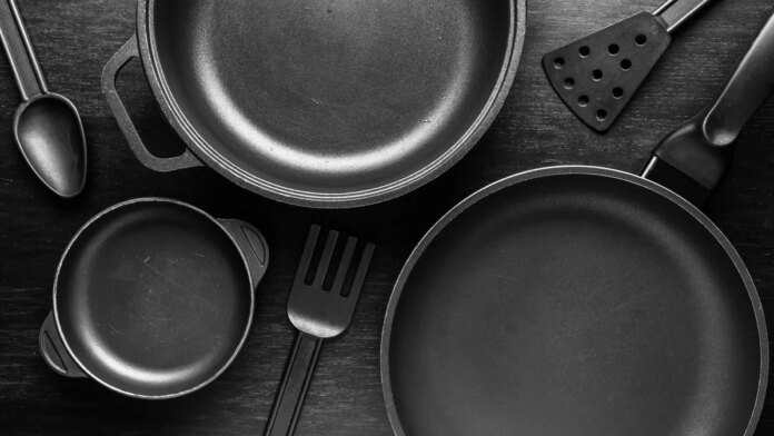 California governor vetoes bill banning'permanent chemicals' in cookware. here's Black frying pans with a non-stick teflon coating on black background