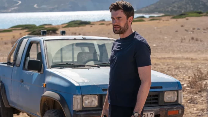 Jack Whitehall in a still from Malice. He&#039;s in front of a battered blue pickup near a lake