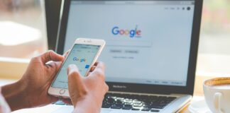 Someone using the Google Search engine on both a mobile phone and an Apple laptop