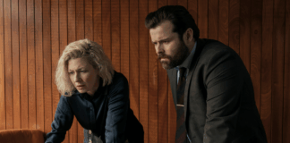 Two police officers look at a computer screen