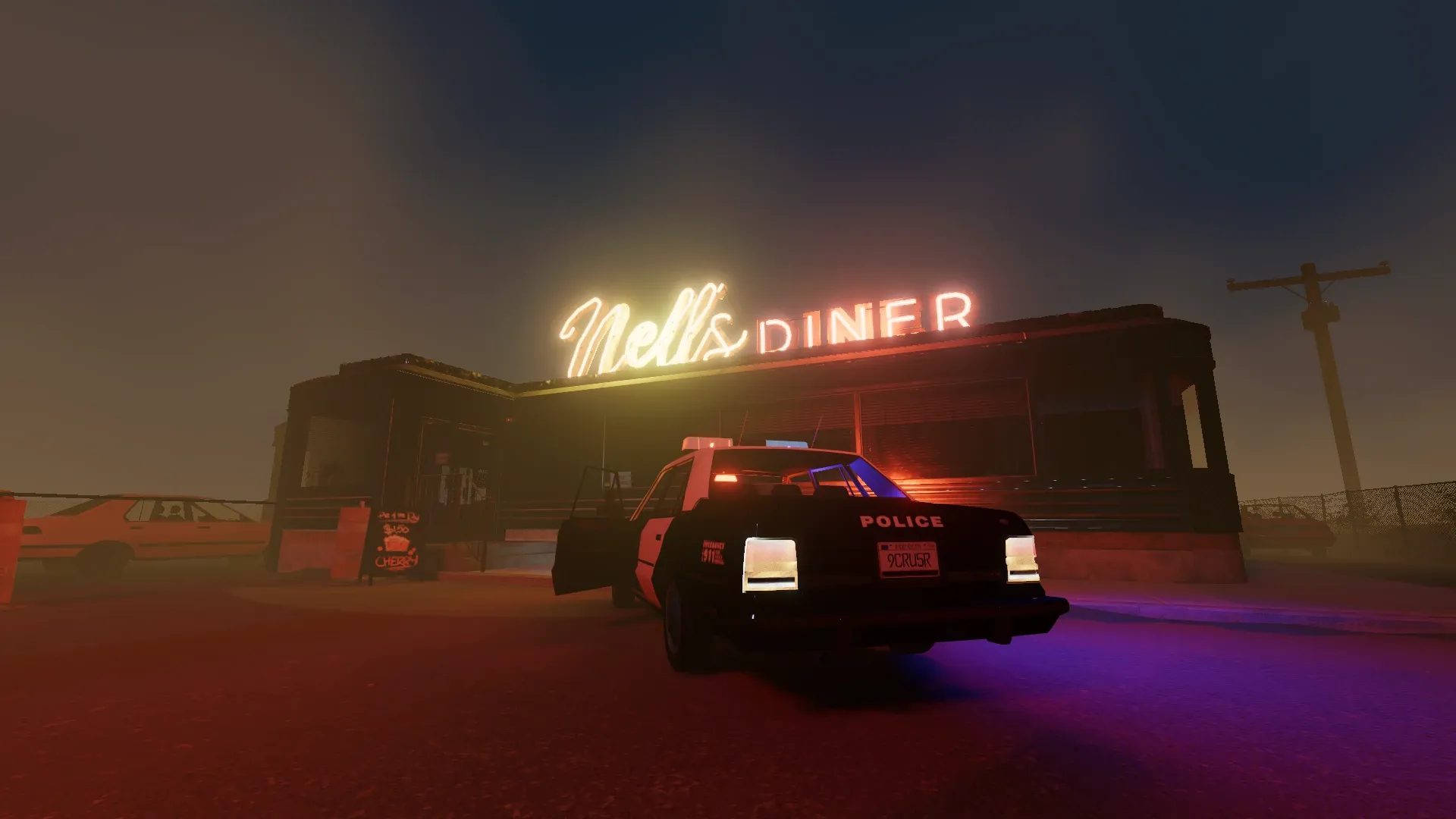 The glowing neon sign of Nell's Diner illuminates a small building, with an abandoned police car outside