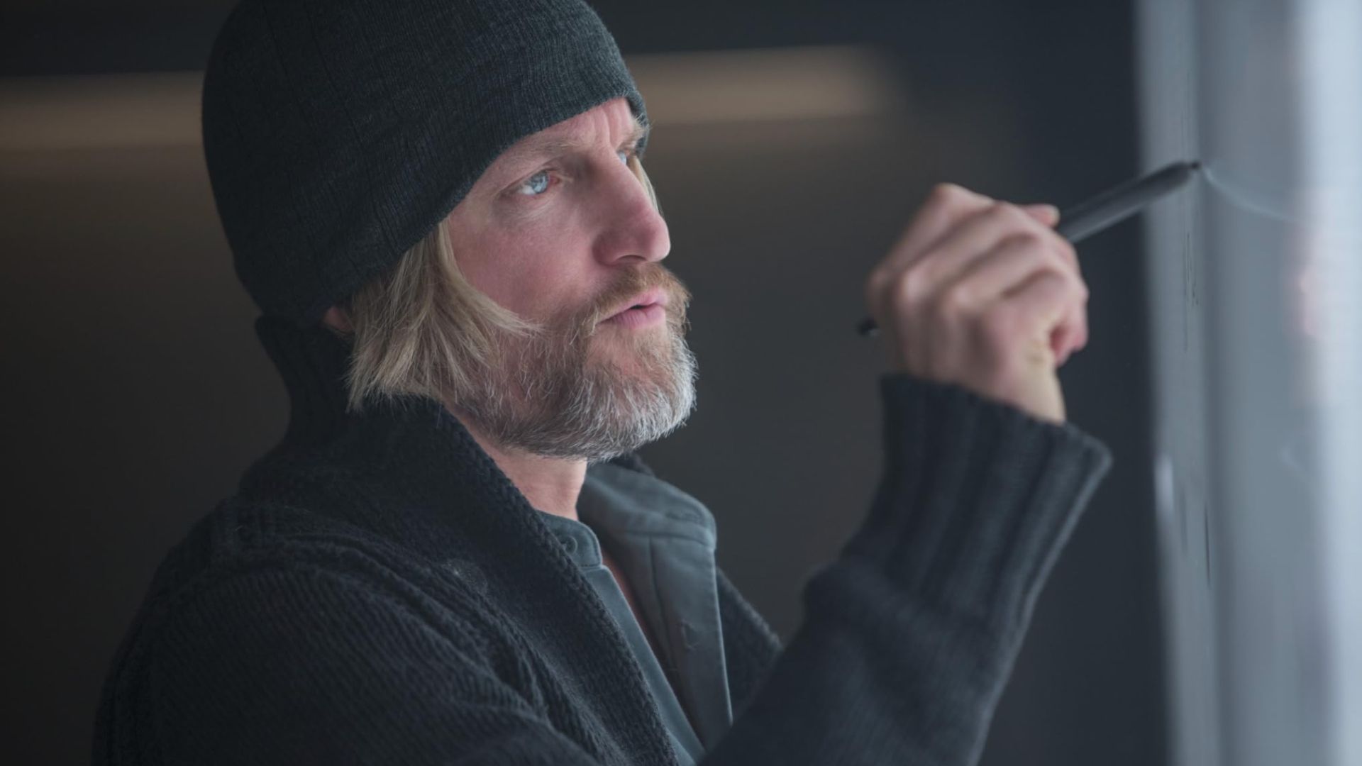 Haymitch draws on a board in The Hunger Games