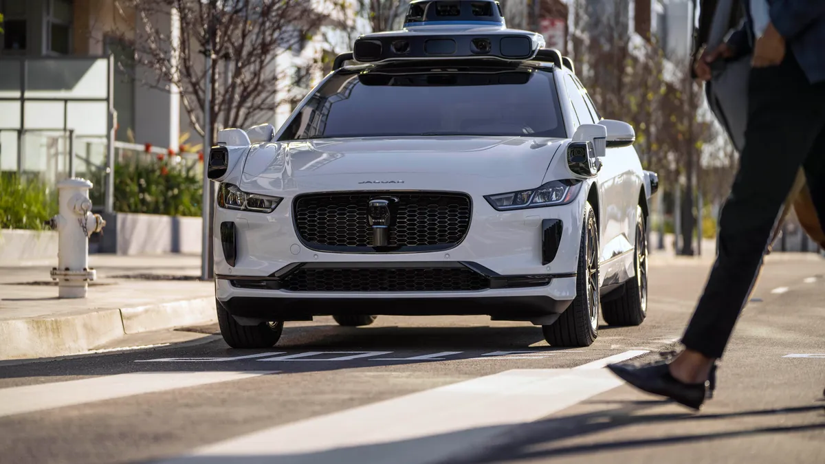 A Waymo Jaguar I-Pace drives on a road
