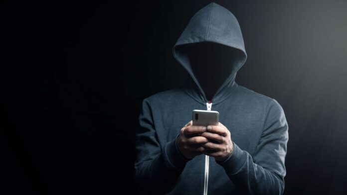 A dark figure in a hoodie representing a hacker.