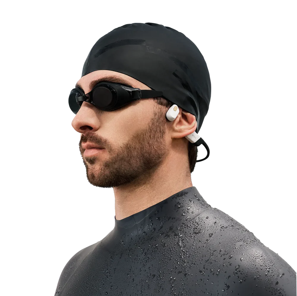Person wearing Shokz OpenSwim Pro bone conduction headphones during outdoor run